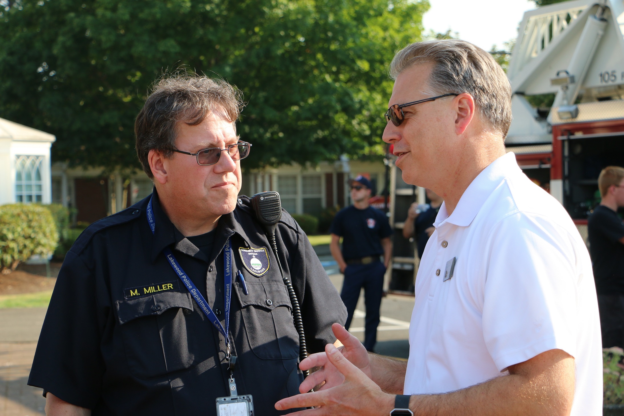 Councilmember Bocchi speaks with a Lakewood officer. 