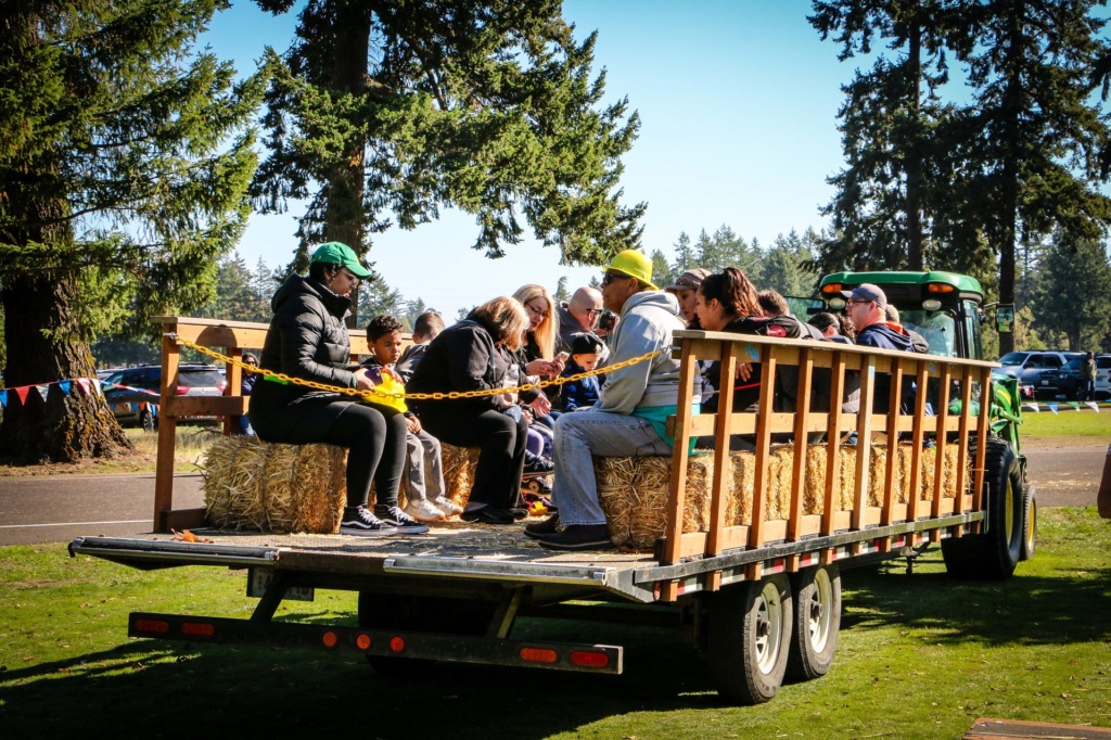 People ride in the back of a haywagon at truck and tractor day