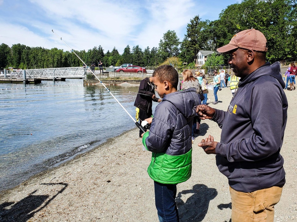 Child holding fishing pole with adult at Lakewood 2019 Ray Evans Memorial Fishing event