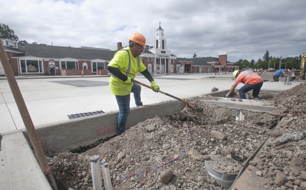 Construction workers work on the concrete at the Lakewood Colonial Plaza in Lakewood, Washington as part of a public infrastructure improvement project in the Lakewood downtown area to promote private development