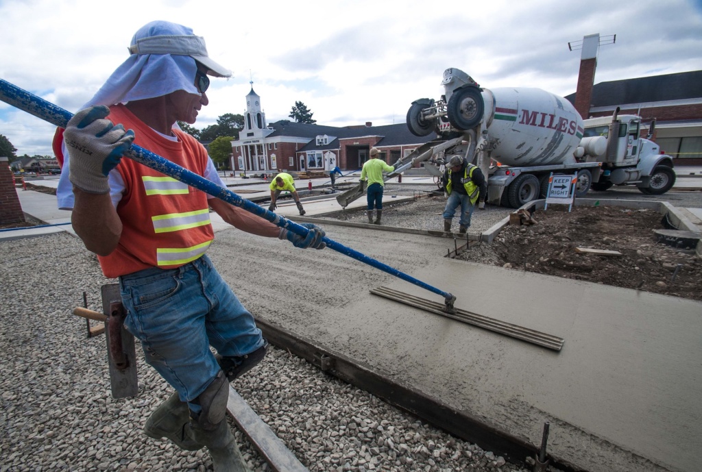 Construction workers work on the concrete at the Lakewood Colonial Plaza in Lakewood, Washington as part of a public infrastructure improvement project in the Lakewood downtown area to promote private development.