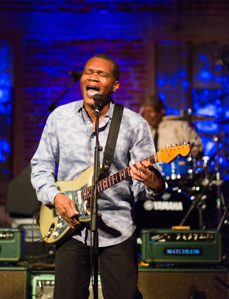 Robert Cray performing on stage with a guitar photo credit James L. Bass
