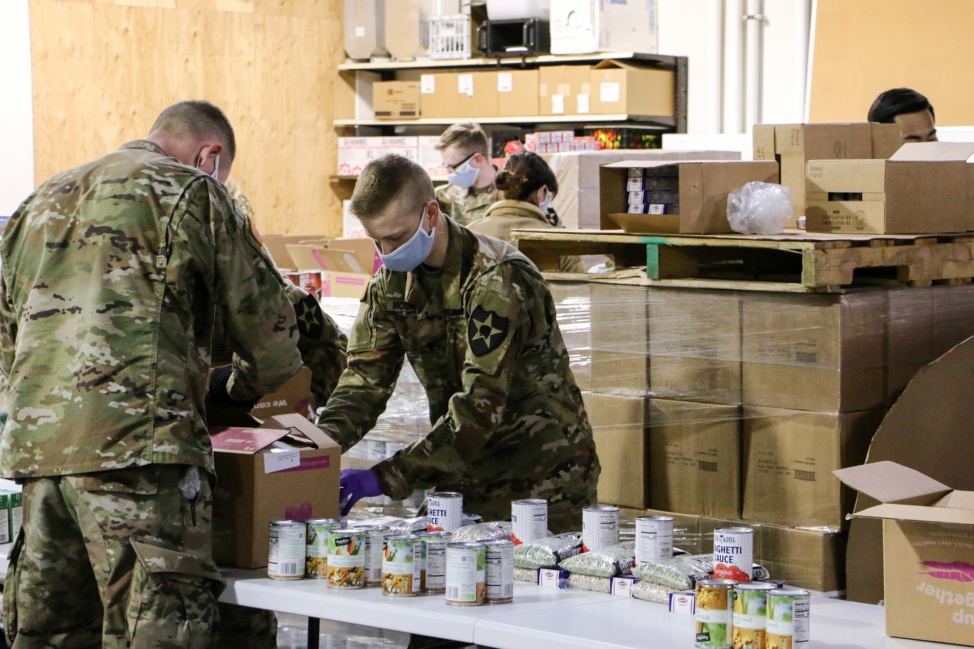 Members of the Washington National Guard prepare canned food items to be distributed to food banks across Pierce County.
