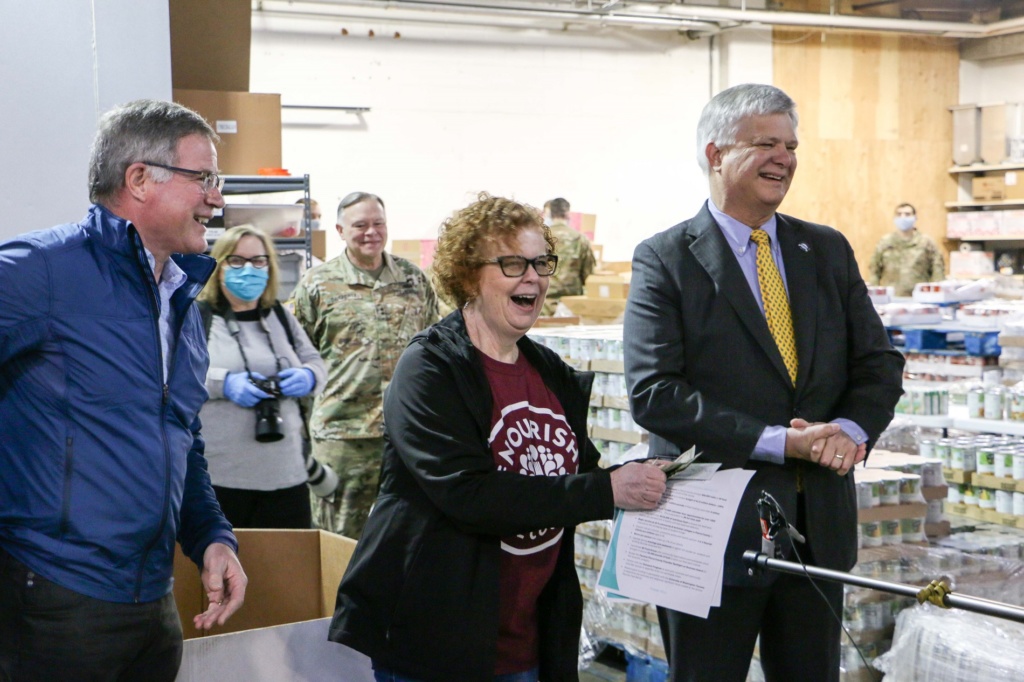 Pierce County Executive Bruce Dammeier, Nourish Pierce County Executive Director Sue Potter and Lakewood, WA Mayor Don Anderson stand together in front of the media in the warehouse of Nourish Pierce County.