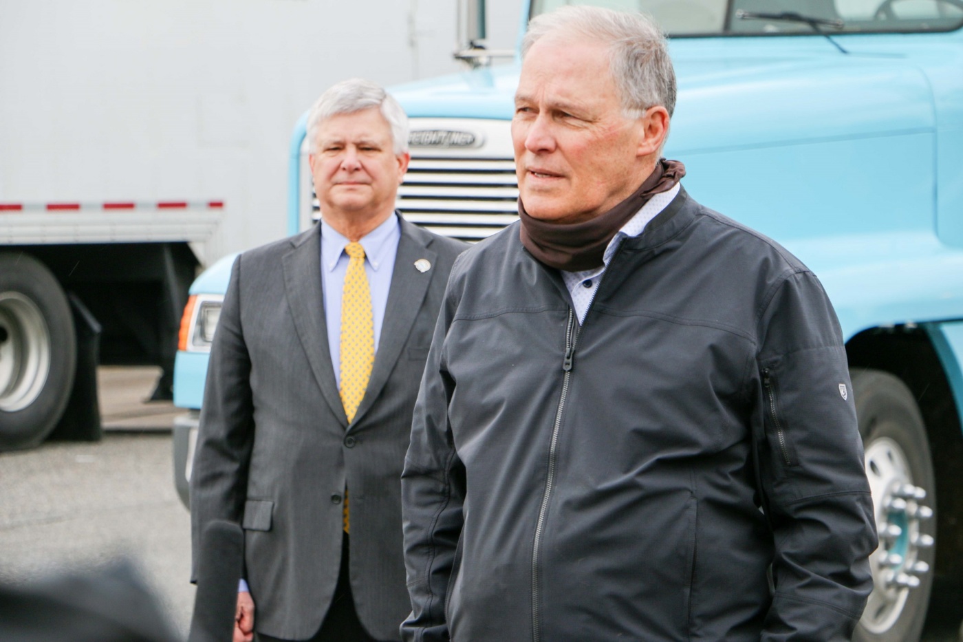 Washington state Governor Jay Inslee addresses the media at Nourish Pierce County, a food distribution center for food banks located in Lakewood, Wa. Lakewood Mayor Don Anderson looks on in the background.