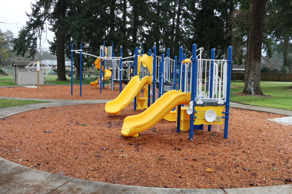 Yellow and blue playset on bark. 