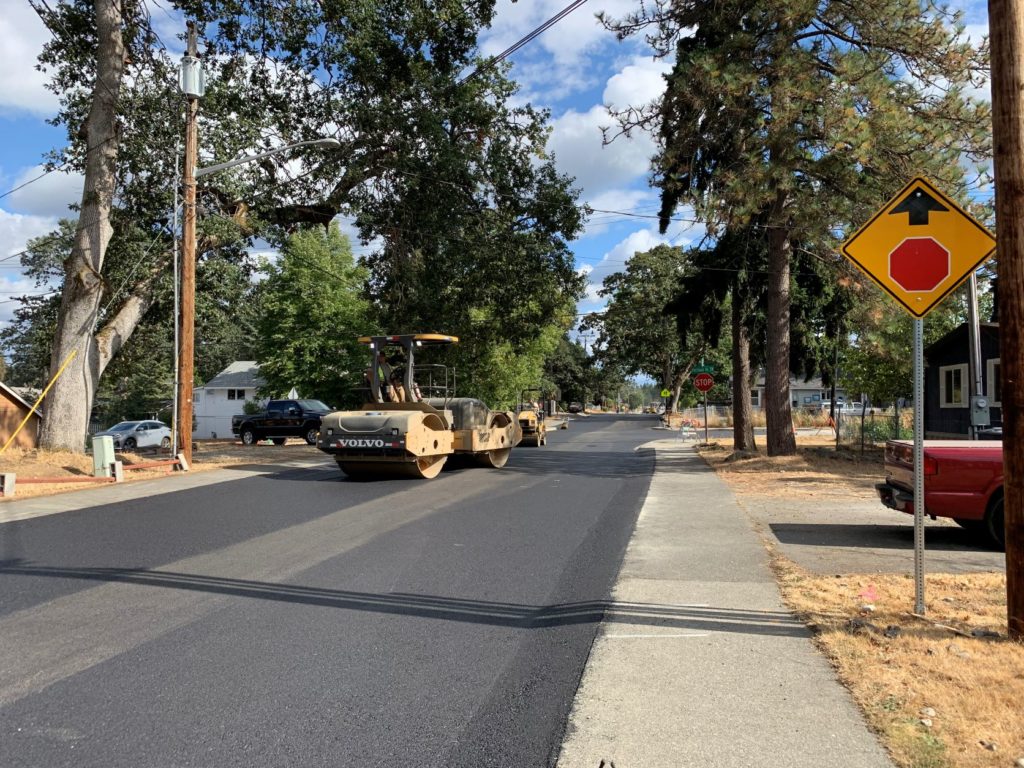 A roller rolls over the new asphalt placed along Maple at Portland