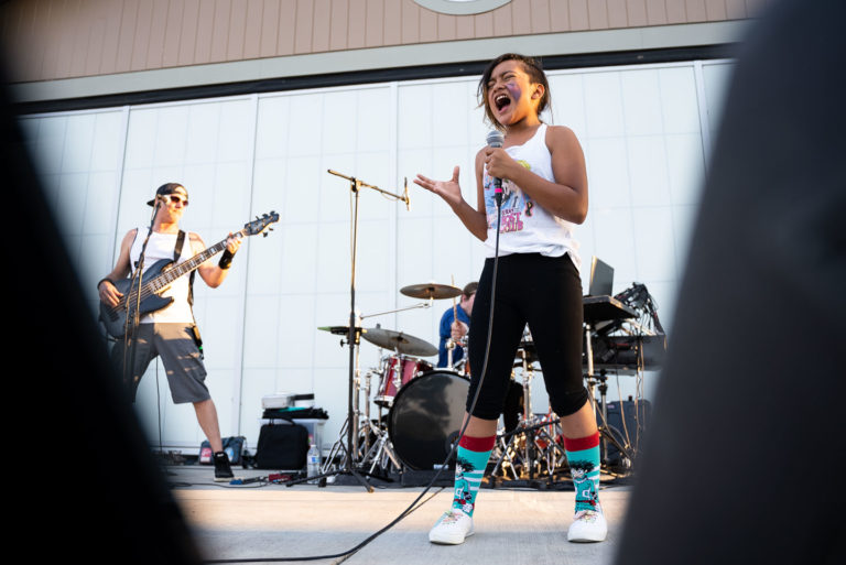 Một cô gái trẻ hát tại Pavilion ở công viên Fort Steilacoom trong một sự kiện hòa nhạc mùa hè.