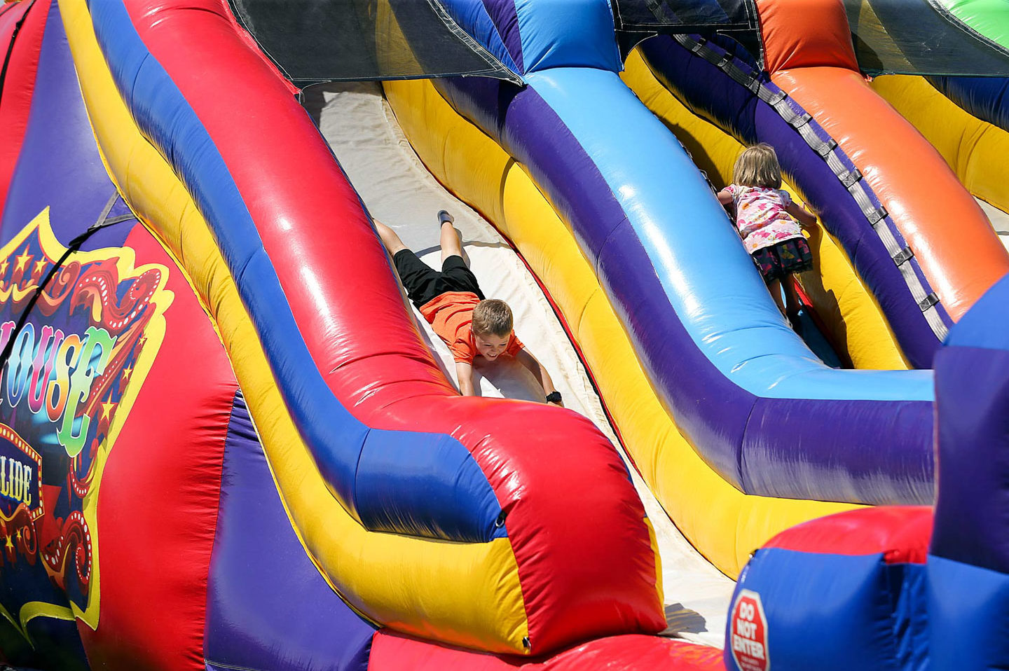 Young child enjoys blow up slide at Lakewood's SummerFEST