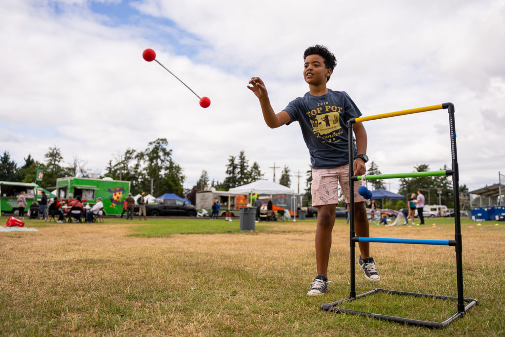 A pre-teen throws the ball during a game of ladder ball. 