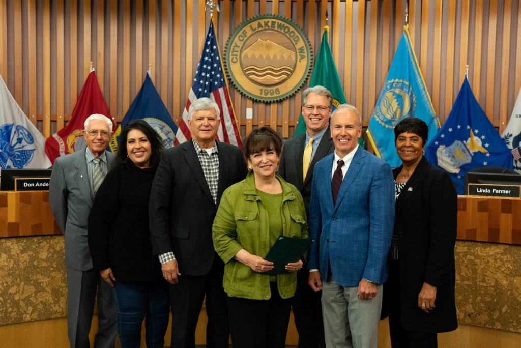 Lakewood City Council with Linda Smith of the Lakewood Chamber of Commerce posing with a proclamation in Lakewood City Council Chambers