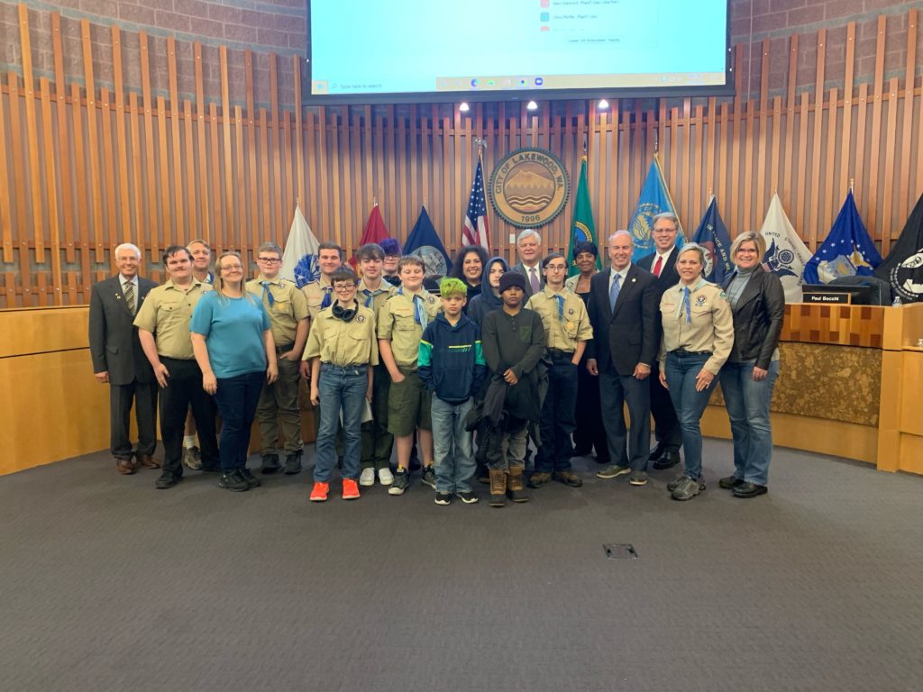 Members of Boy Scout Troop 53 located in Lakewood. WA stand with the Lakewood City Council at the front of the Council Chambers.