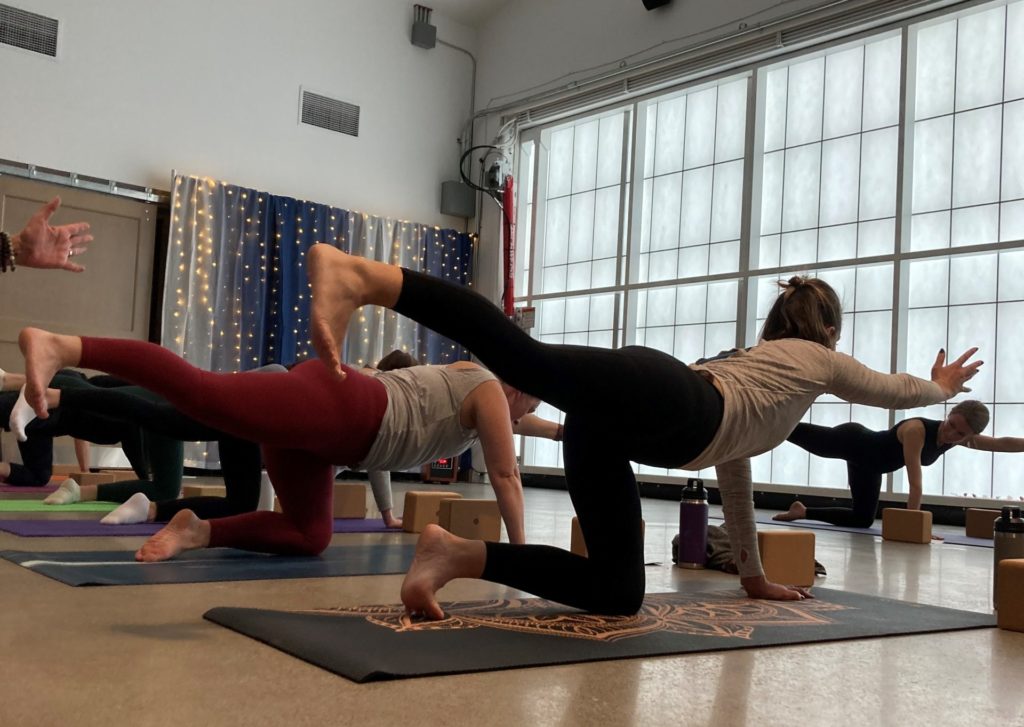 People hold a yoga pose at the Pavilion at Fort Steilacoom Park