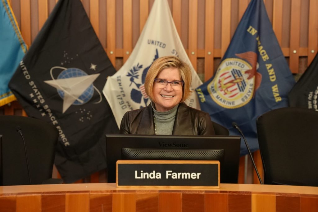 Lakewood City Council member Linda Farmer smiling behind the dais in Lakewood Council Chambers.