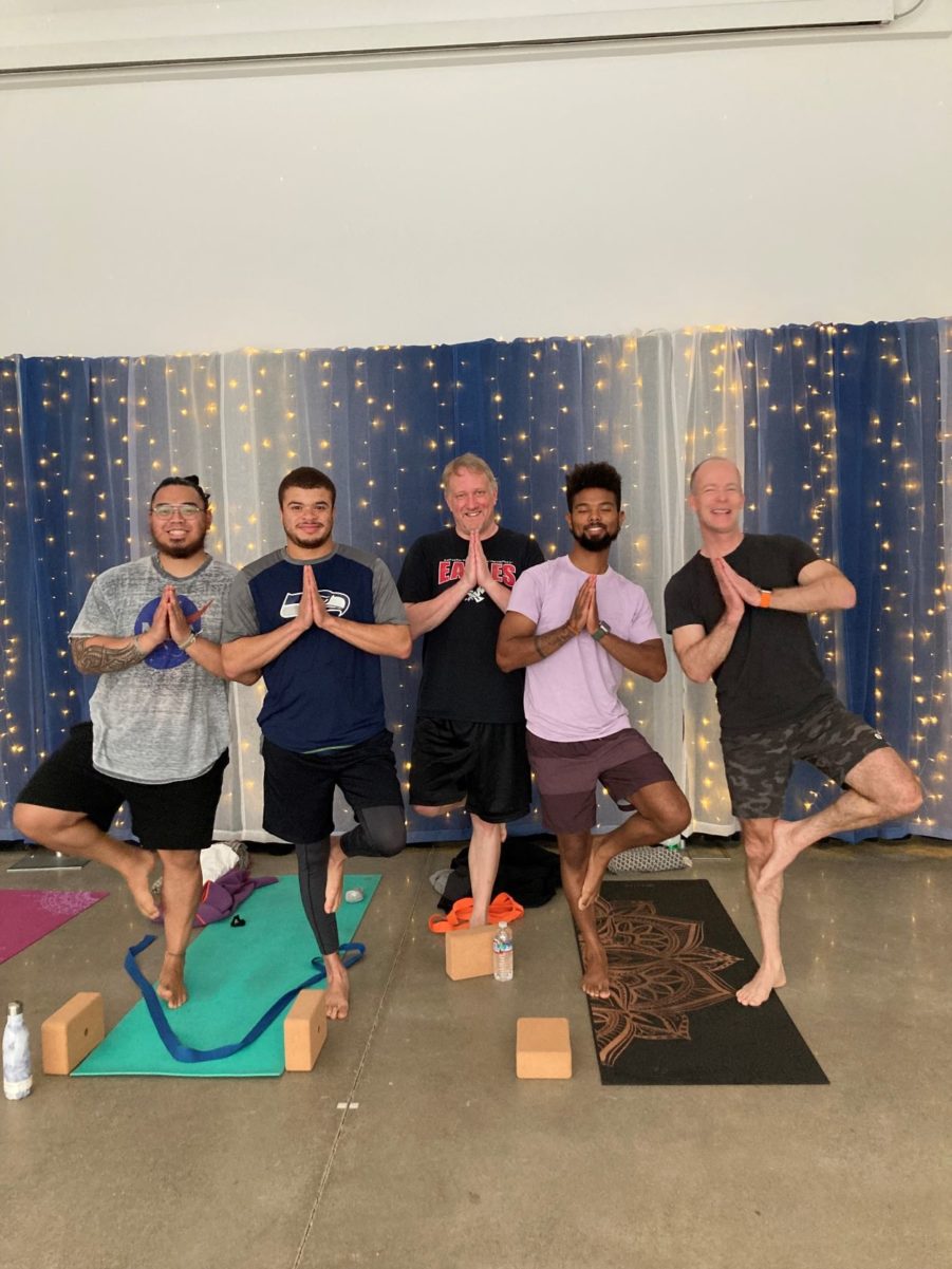 Five men stand in a "tree pose" inside the Lakewood Pavilion for the #LoveLakewood Yoga series.