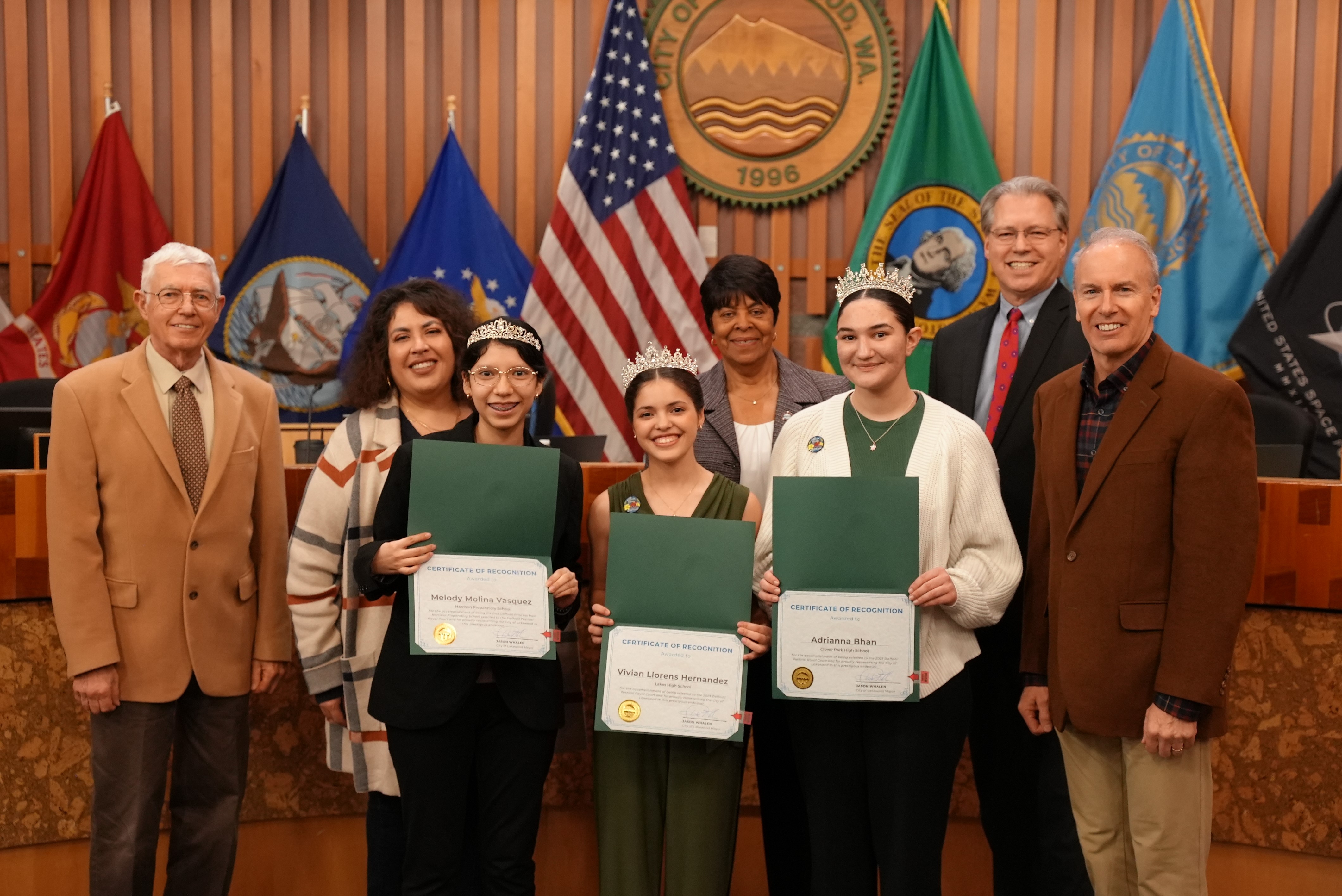 Members of the 2023 Daffodil Festival Royal Court stand with the Lakewood City Council holding certificates in the Lakewood Council Chambers.