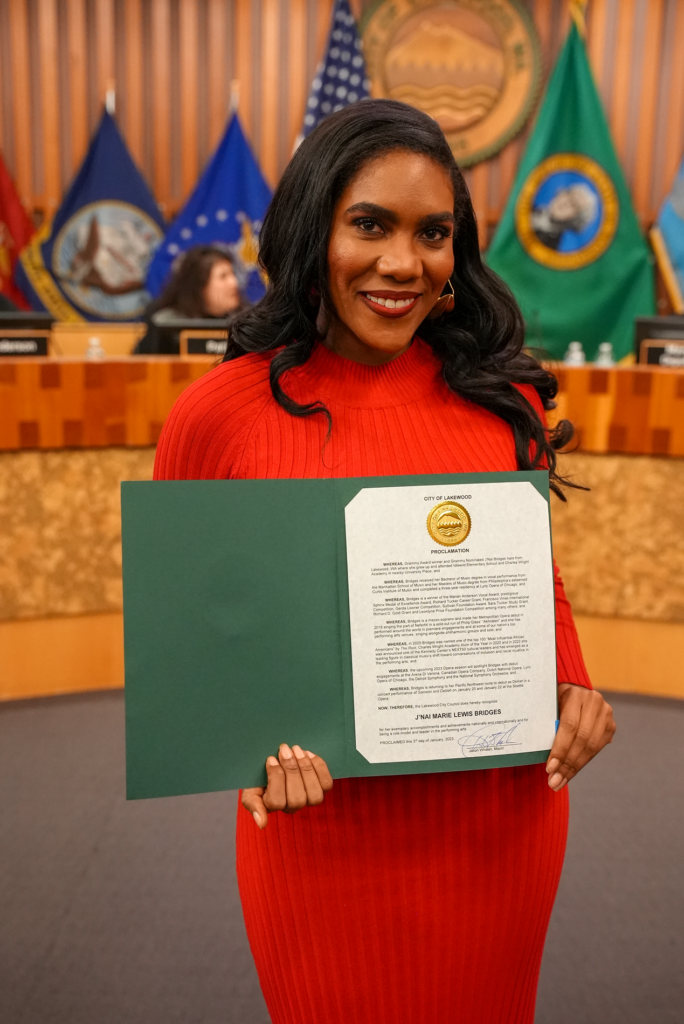 Lakewood resident and Grammy Award-winning opera singer J'Nai Bridges poses with a proclamation at the front of the Lakewood City Council chambers.