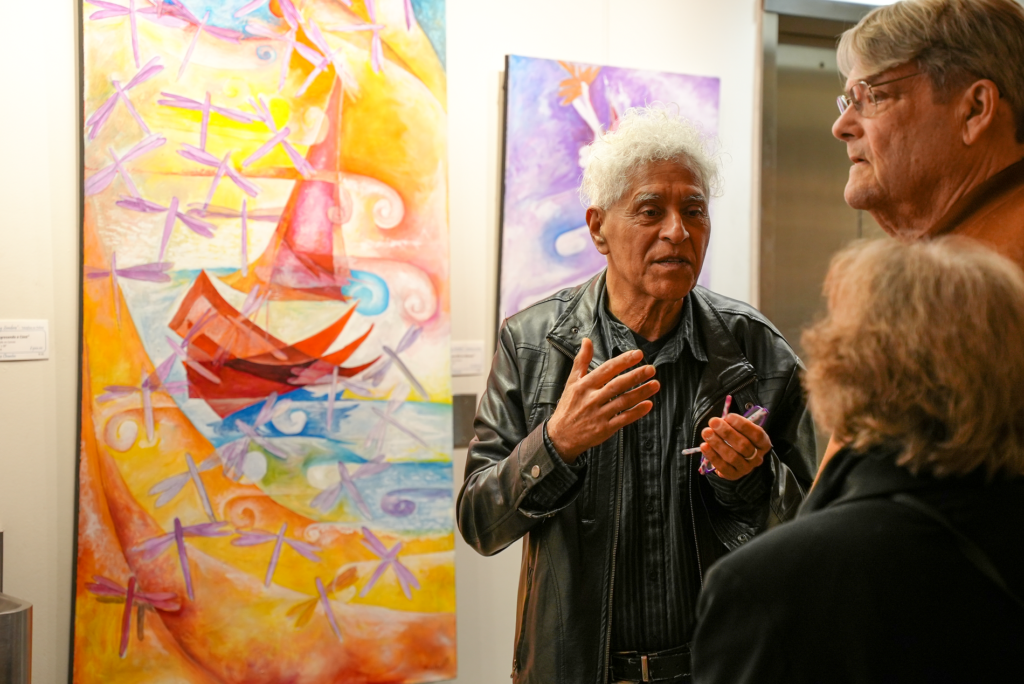 Artist Jose Orantes explains his art to curious onlookers.