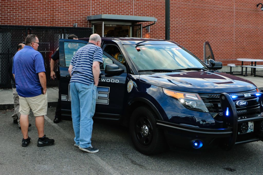 Attendees look through a Lakewood police car