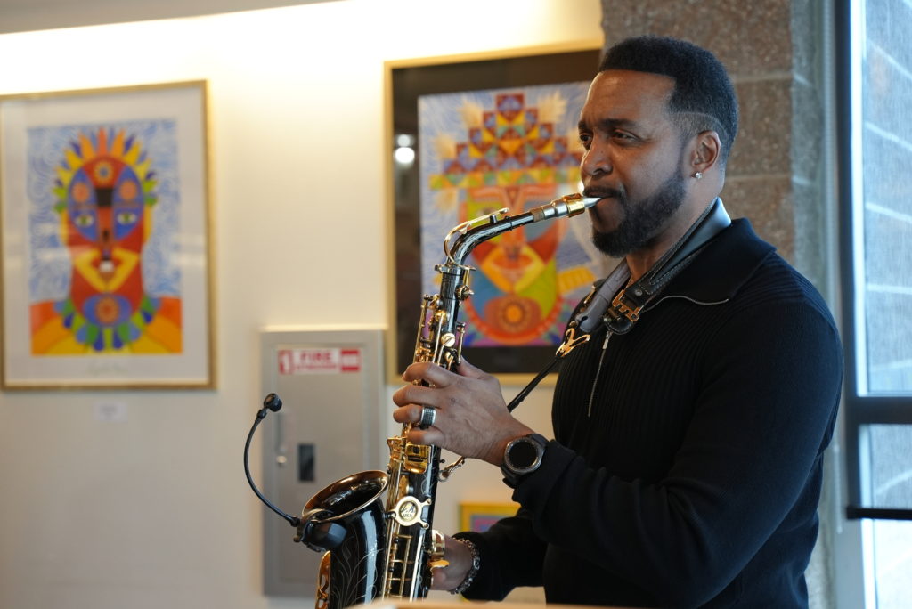 A saxophonist plays for people at the Lakewood art reception. 