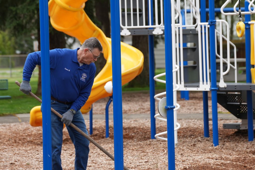 A volunteer spreads woodchips at Kiwanis Park
