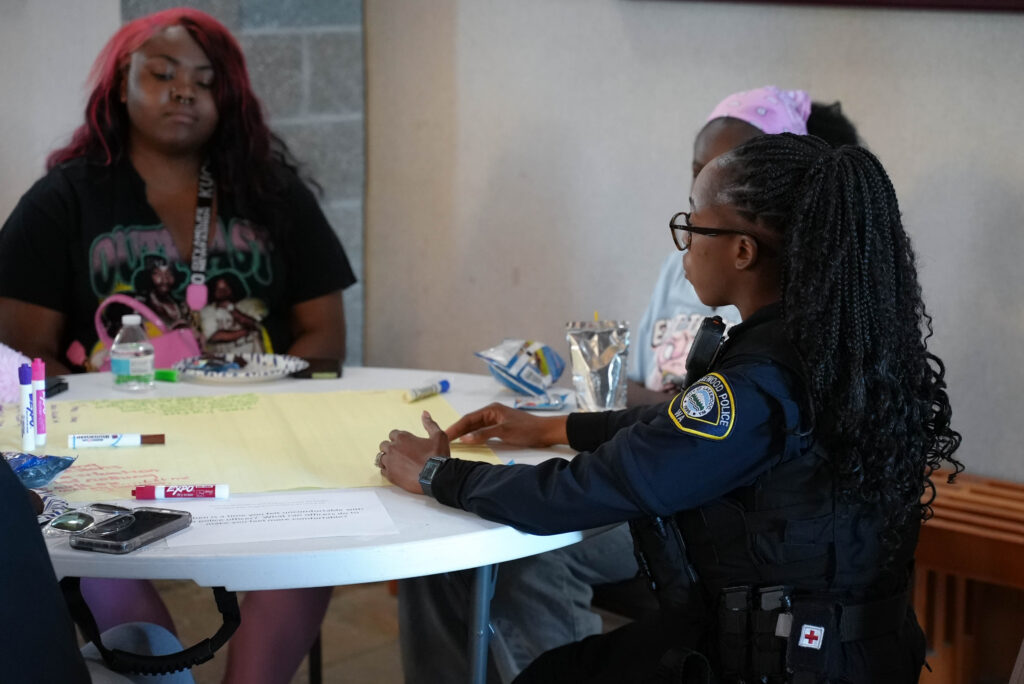 A Lakewood Police officer has a conversation with members of the Lakewood Youth Council