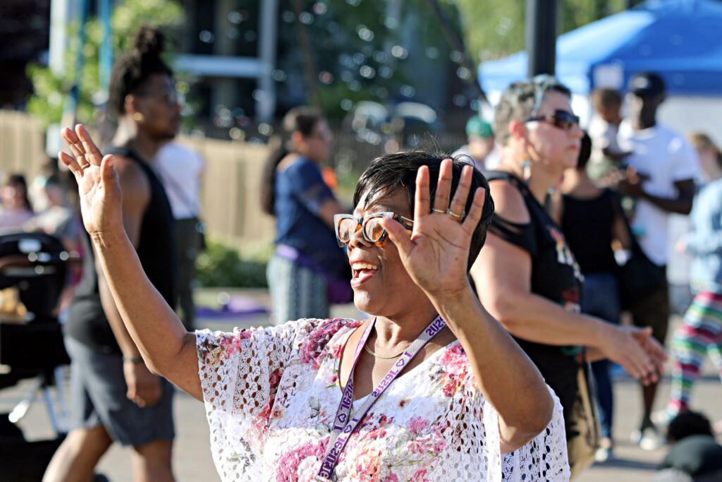A woman holds her hands up and dances at the June 3, 2023 Lakewood Dancing in the Streets Saturday Street Festival.