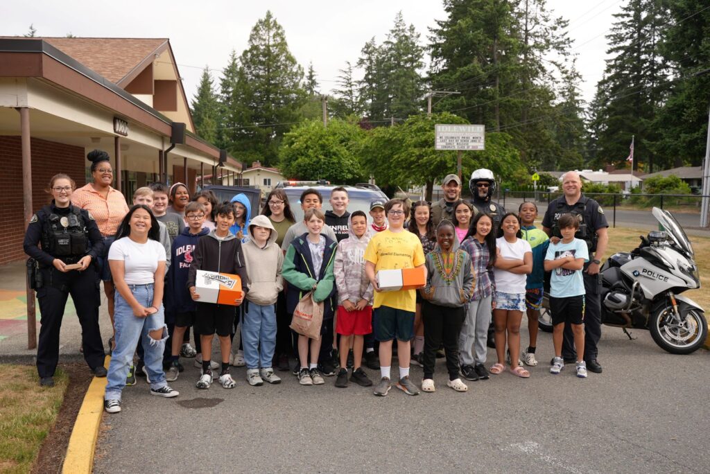 A 5th grade class from Idlewild Elementary School pose with members of the Lakewood Police Department outside the school.