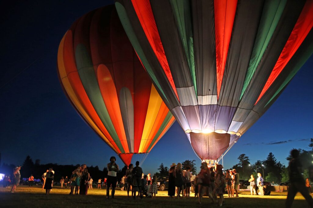 Hot air balloons tethered to the ground glow against the night sky at Lakewood SummerFEST 2023.