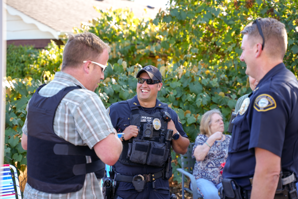 Un officier de police de Lakewood sourit tandis que d'autres regardent l'événement National Night Out 2023 dans la ville le 1er août 2023