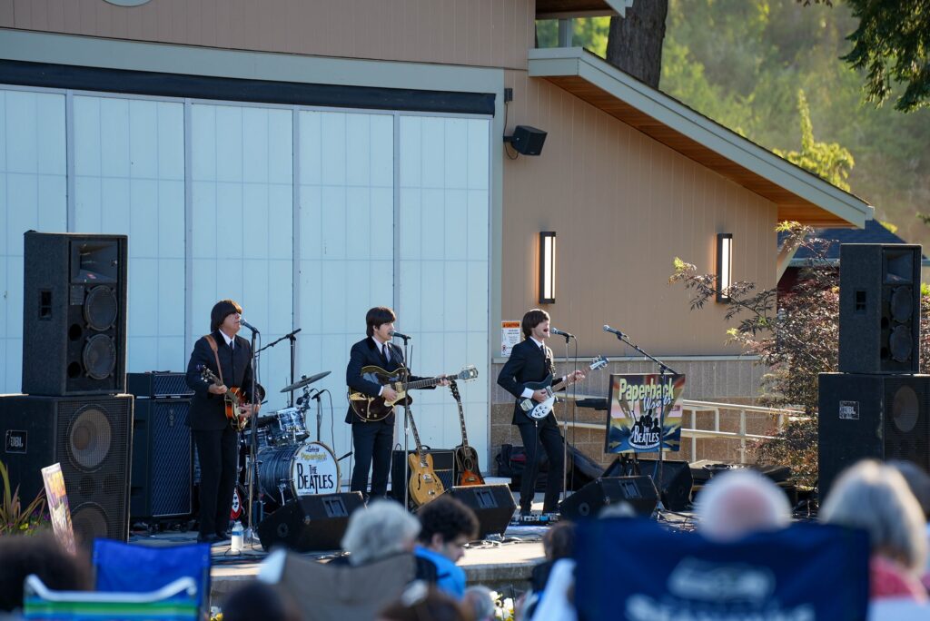 Les membres du groupe Paperback Writer se produisent sur la scène du pavillon du parc Fort Steilacoom à Lakewood, WA, pour la série de concerts d'été gratuits de la ville.
