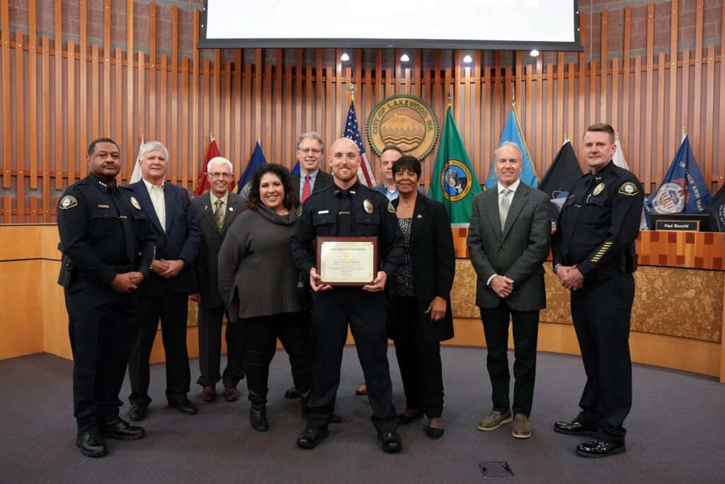 Lakewood Police Officer Stephen Moffitt stands with the Lakewood City Council