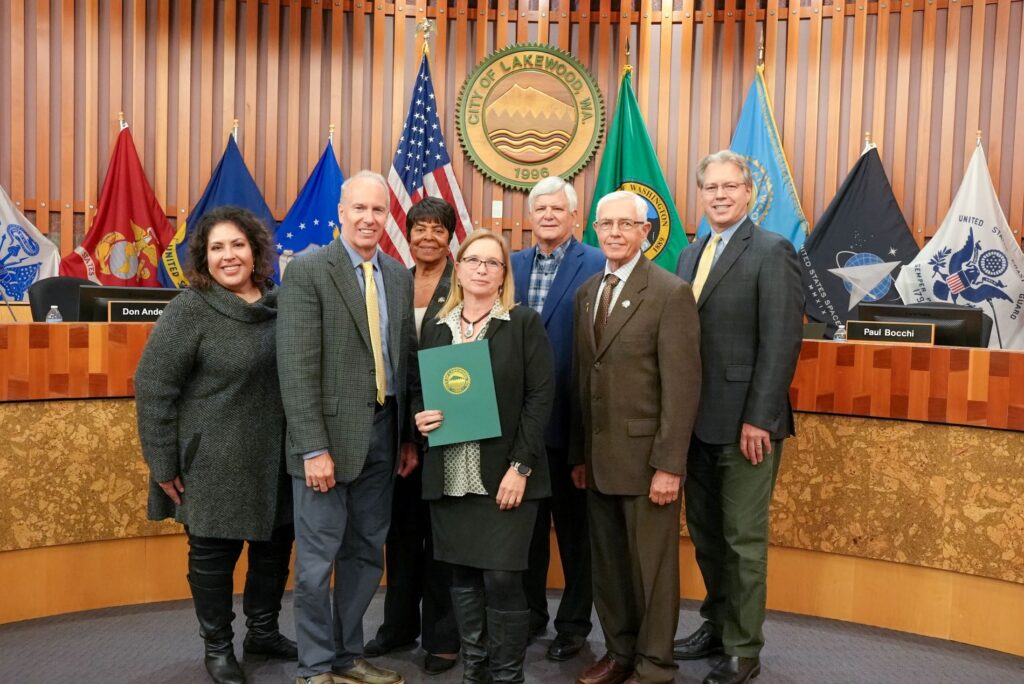 The Lakewood City Council poses with Lakewood Assistant City Attorney Lise Schumacher who holds a proclamation recognizing December as Domestic Violence Awareness Month