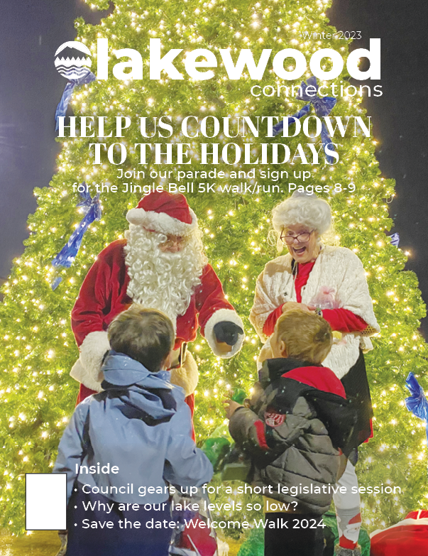 Winter 2023 Lakewood Connections Cover. A picture of Santa and Mrs. Claus in front of the Lakewood Christmas Tree smiling at two young children,