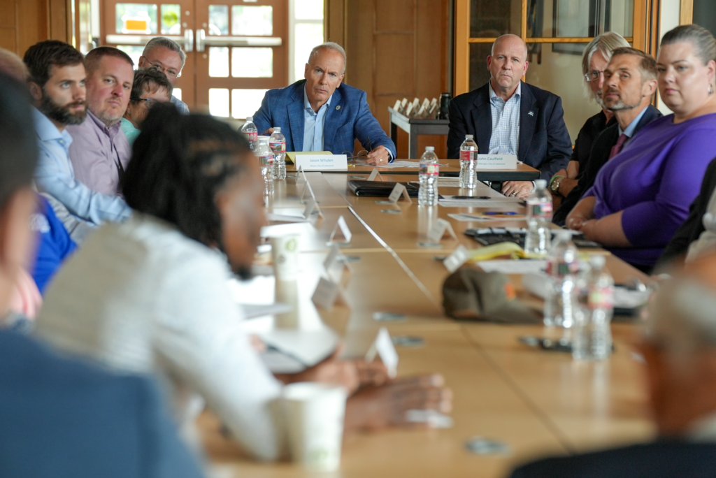 Mayor Jason Whalen and City Manager John Caulfield sit at the head of a table filled by Mayors and City Administrators from across Pierce County.