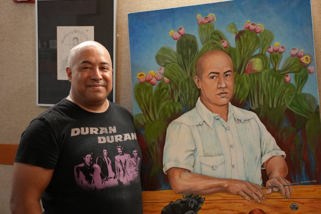 Local artist Rene Julio poses with a self-portrait in Lakewood City Hall.