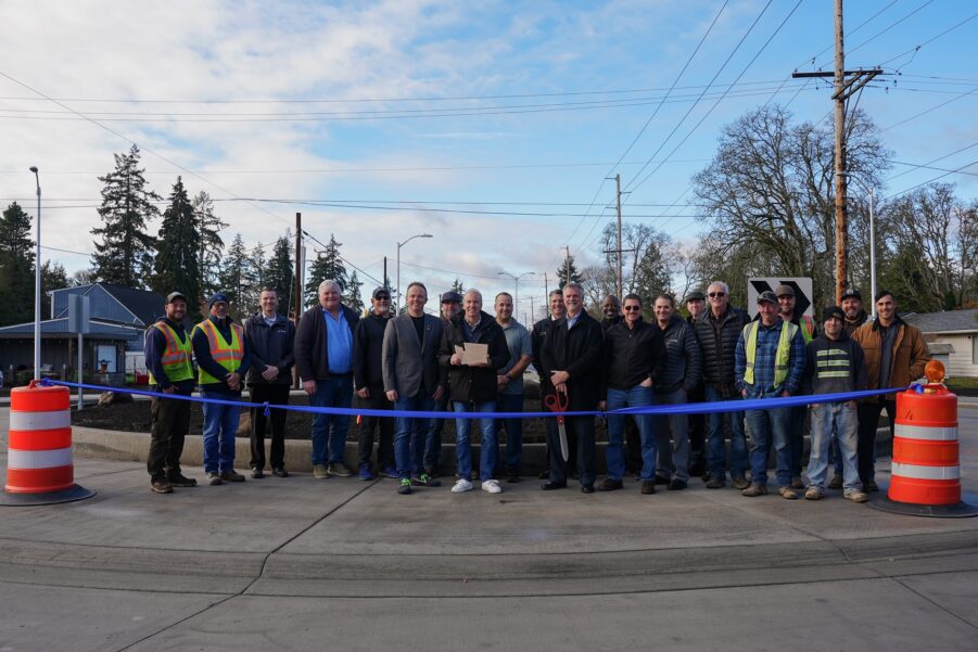 A group of people pose with Mayor Jason Whalen and Councilmember Trestin Lauricella at the ribbon cutting for Washington Boulevard in Lakewood, WA Nov. 22,2023