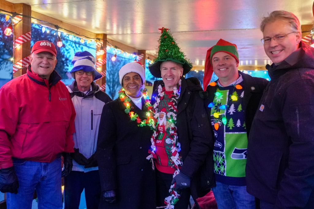 The Lakewood City Council wearing holiday attire poses and smiles for the camera at the 2023 Holiday Parade of Lights