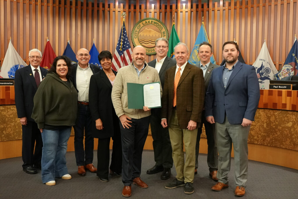 The Lakewood City Council poses with a representative from the American Red Cross Pacific Northwest Region at a meeting after declaring March 2024 American Red Cross month.
