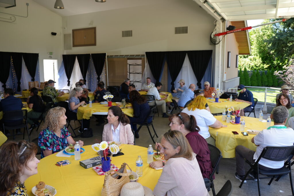 Groups of people enjoy food and conversation in the Fort Steilacoom Park Pavilion. 