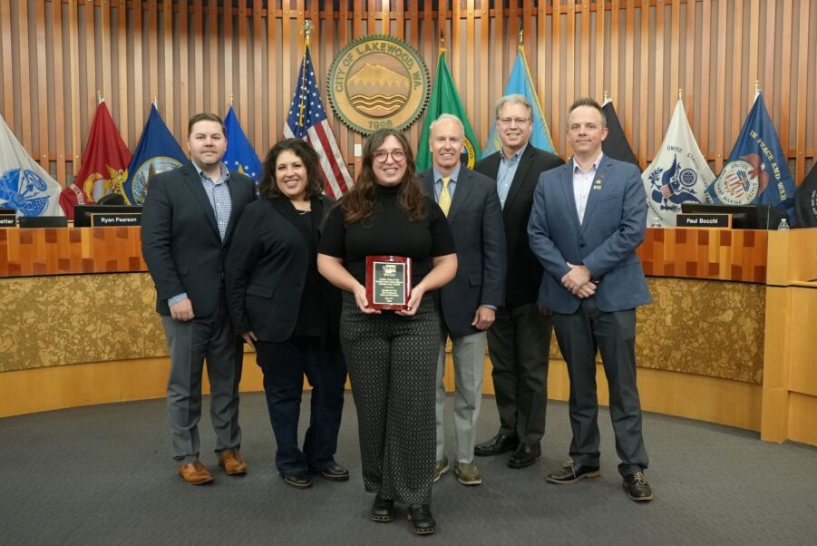 Stacey Reding, Capital Projects Manager for Lakewood Parks, Recreation and Community Services holds an award with the Lakewood City Council after the city was recognized for its Springbrook Park improvements.