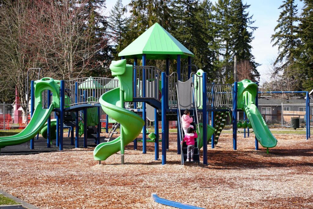 Children climb up a playground ladder at Springbrook Park in Lakewood, WA in March 2023.