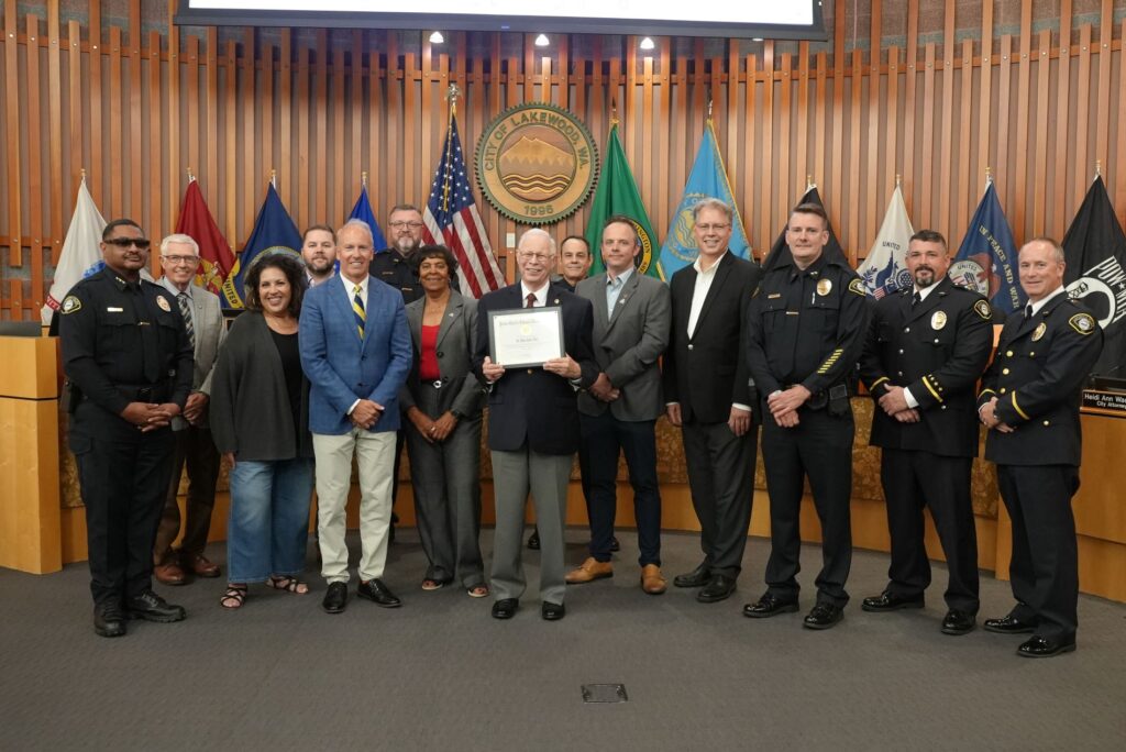 Dr. Alan Hart poses with the Lakewood City Council and members of the Lakewood Police Department after being recognized for his volunteerism in August 2024.