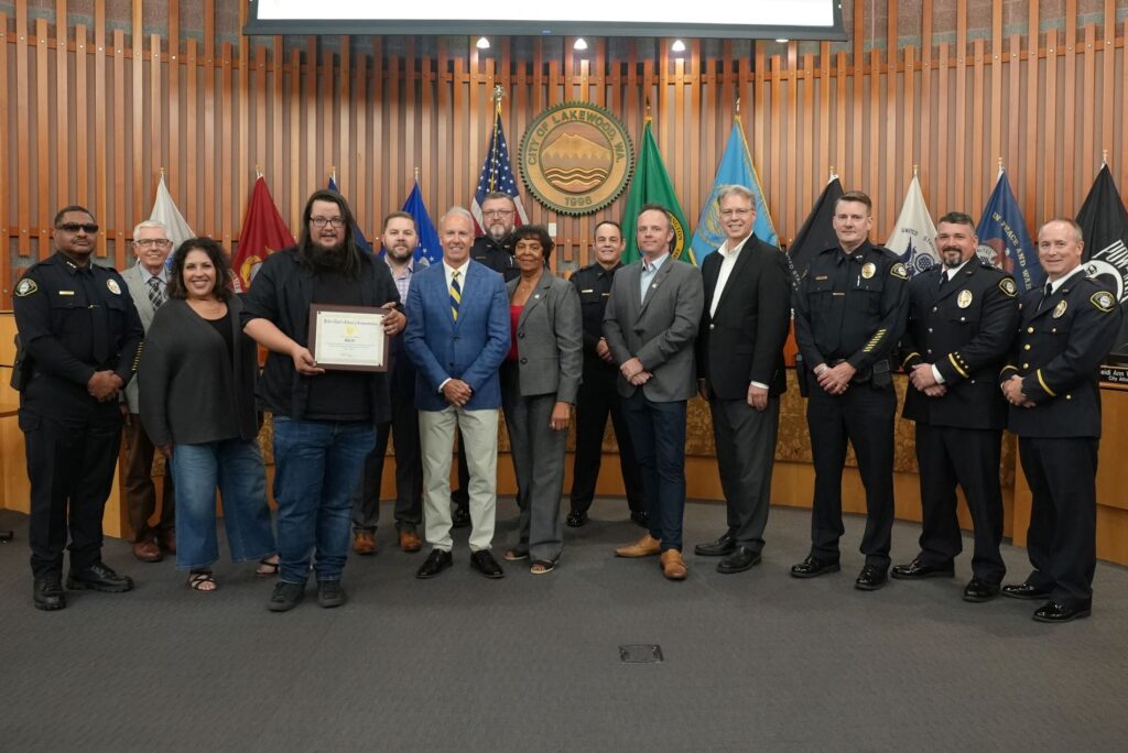 Business owner Mike Ott poses with the Lakewood City Council and members of the Lakewood Police Department after being recognized for his help in a police case in August 2024.