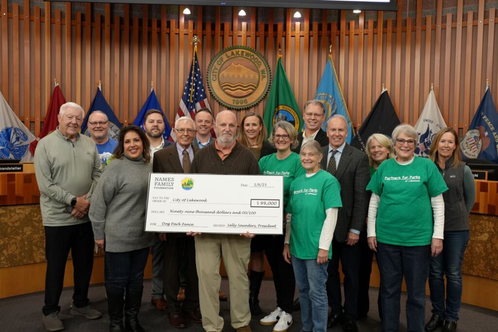 Members of Partners for Parks pose with the Lakewood City Council while holding a large sized check at the Jan. 6, 2025 City Council meeting.