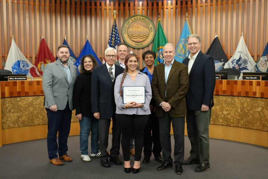 Lakewood City Council posing with Juanita Lanier holding up her certificate.