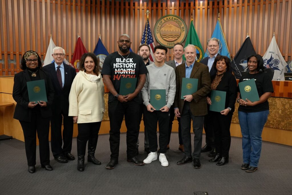 Members of the Lakewood City Council stand with the 2025 Hidden Heroes in the front of the Lakewood Council Chambers.