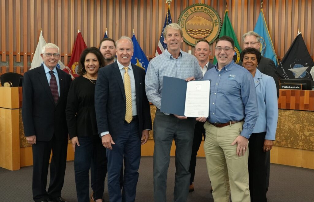 The Lakewood City Council pose with representatives from Lakewood Water District. They hold a proclamation declaring Drinking Water Week 2025.