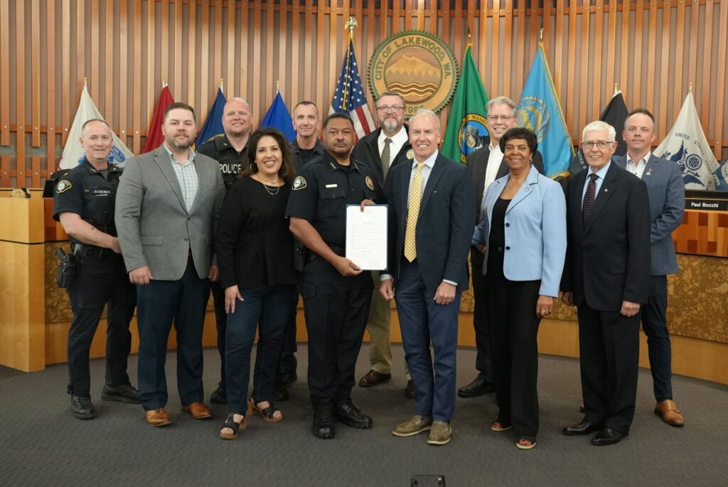 The Lakewood City Council poses with members of the Lakewood Police Department. Police Chief Patrick D. Smith stands in the center holding a proclamation declaring May 11-17, 2025 as National Police Week.