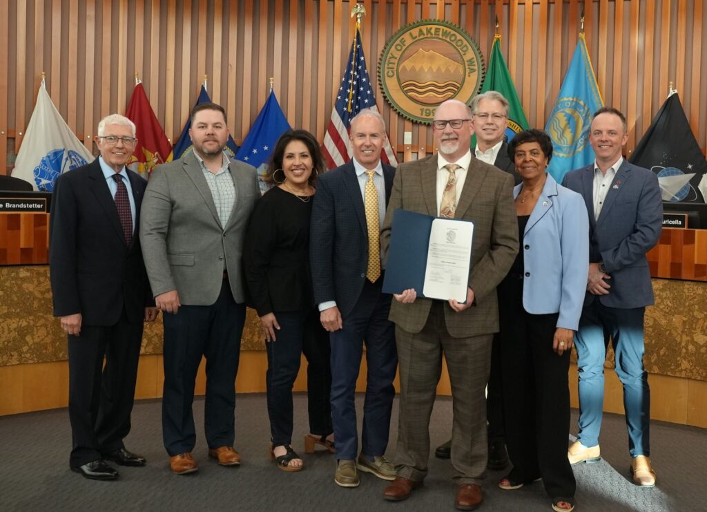 The Lakewood City Council pose with City Engineer Weston Ott. He is holding a proclamation declaring National Public Works Week 2025.